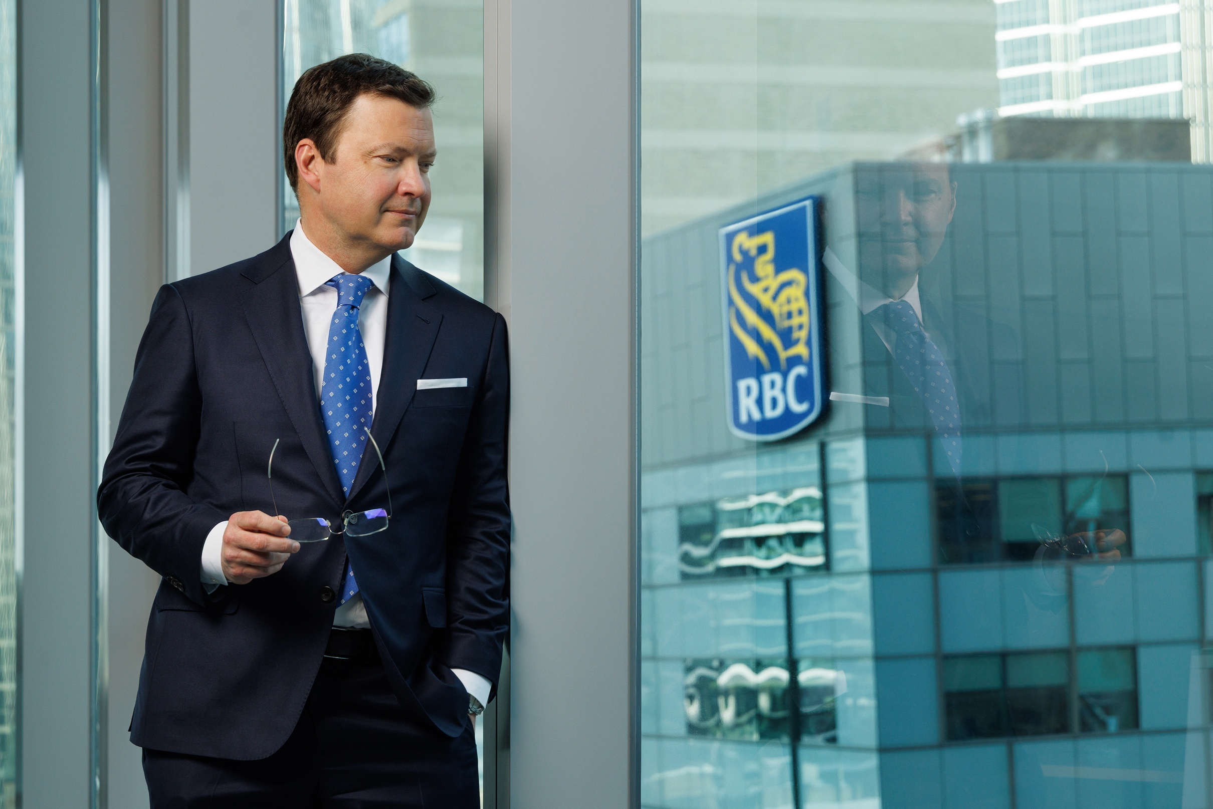 Stuart Kedwell standing in front of a surface reflecting the RBC logo